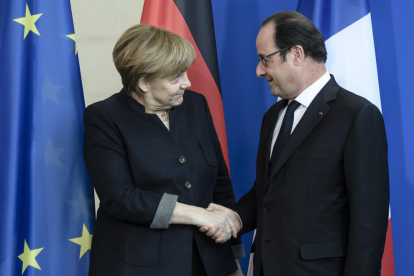 Merkel estreny la mà d’Hollande.