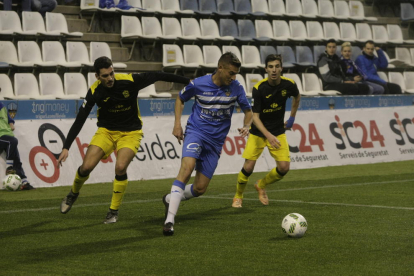 Marc Nierga supera dos jugadors del Prat en una acció del partit d’ahir al Camp d’Esports.