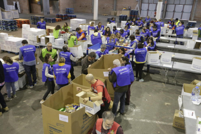 Voluntarios clasificaban ayer los  productos donados en el pabellón 3 de los Camps Elisis. 