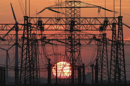 A la imatge, una posta de sol darrere la línia elèctrica.