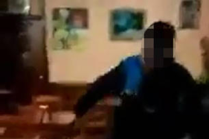 Fragmentos del vídeo en el que se ve a un urbano agrediendo a un joven, incluso con una silla. 