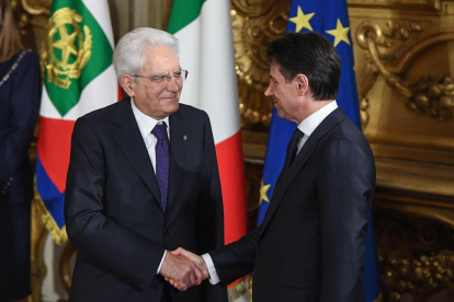Giuseppe Conte  estrecha la mano del jefe del Estado, Sergio Mattarella, tras tomar posesión.