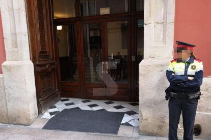 La porta de la Diputació del carrer del Carme, on es troben agents dels Mossos d'Esquadra i mitjans de comunicació a l'espera que surti Joan Reñé.