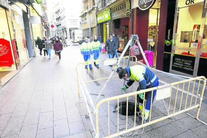 Un operari d’Aigües Lleida treballa en el clavegueram al carrer Major.