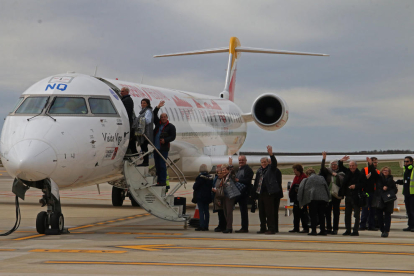 Passatgers pujant a un avió aquest divendres a la pista de l'aeroport de Lleida-Alguaire.