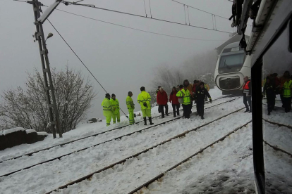 Operarios y efectivos que participaron en el ‘rescate’ de pasajeros, el tren Alvia parado al fondo.