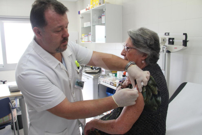 Un infermer administra la vacuna de a grip.