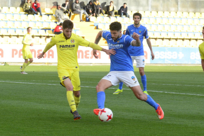 Trilles intenta superar la entrada de un jugador del Villarreal B, en una acción del partido de ayer.