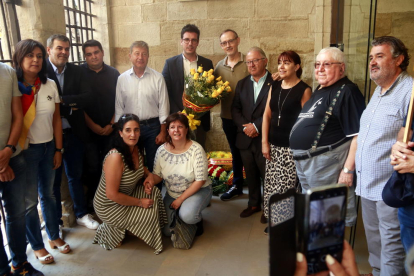 El tinent d'alcalde de la Paeria, Toni Postius (JxCat), amb membres de la formació abans de dipositar l'ofrena floral al Roser.