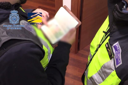 Agentes revisando pasaportes durante el operativo policial. 