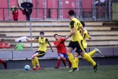 Un jugador del Balaguer pasa el balón a un compañero ante la presión de un rival.