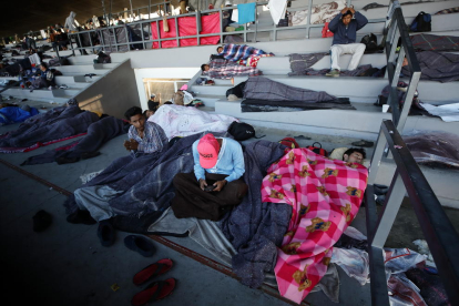 Varios migrantes descansan en un centro deportivo de México D.F.