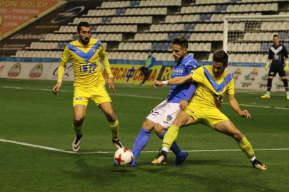 Javi López pugna amb un jugador del Badalona, en una acció del partit disputat ahir en el Camp d’Esports davant de molt poc públic.