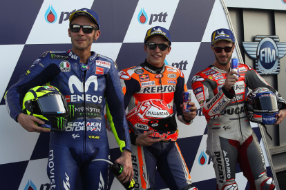 Marc Màrquez celebra la seua ‘pole’ en el Gran Premi de Tailàndia al costat dels italians Valentino Rossi i Andrea Dovizioso.