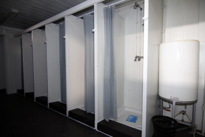 Els mòduls instal·lats a l’interior del pavelló 3 de la fira per atendre els temporers i, a la dreta, les dutxes que s’hi han habilitat.