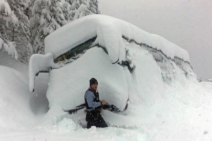 Afectats per la intensa nevada a Bellver de Cerdanya provant de col·locar cadenes als vehicles.