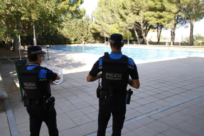 Dos agentes de la Guardia Urbana, ayer en las piscinas de Gardeny. 