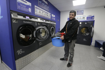 Uno de los clientes haciendo la colada en la lavandería La Colada Lleida, con tres lavadoras y dos secadoras de autoservicio. 