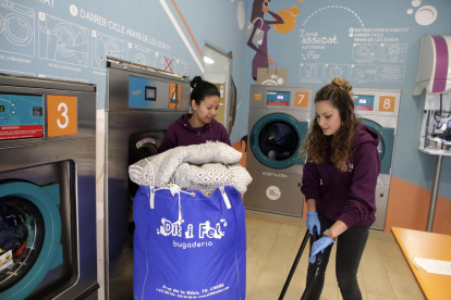 Uno de los clientes haciendo la colada en la lavandería La Colada Lleida, con tres lavadoras y dos secadoras de autoservicio. 