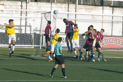 Un defensor del Lleida B s’eleva per sobre dels altres per rebutjar una pilota aèria.