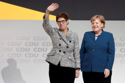 Annegret Kramp-Karrenbauer saluda els militants del CDU acompanyada de Merkel, ahir.