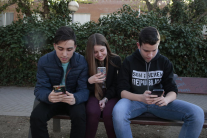 Tres amics de Pardinyes, navegant per la xarxa amb els mòbils davant de l’institut Josep Lladonosa.