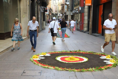 Més de setanta persones van confeccionar disset catifes de flors i serradures acolorides que van decorar l'Eix Comercial.