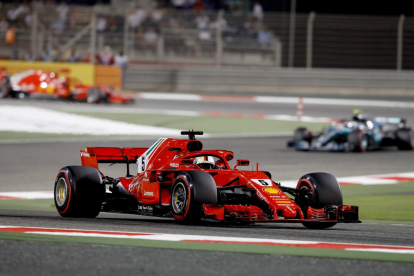 Sebastian Vettel celebra el triunfo en el circuito de Bahrein con uno de sus mecánicos ayer tras la carrera.