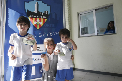 Tres niños posan con sus entradas para el partido de Sabadell tras adquirirlas ayer en el club.