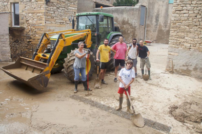 Vecinos de Vilagrasseta, en Montoliu de la Segarra, limpiaban ayer los restos de barro en la plaza de la Iglesia. 