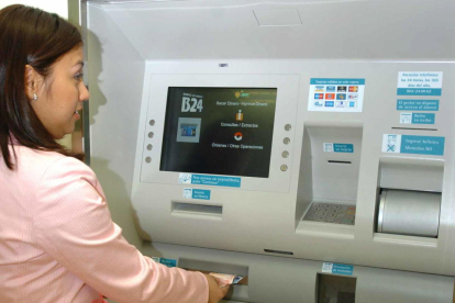 Imagen de una mujer retirando efectivo de un cajero automático.