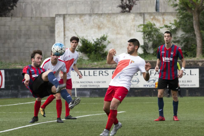 Un jugador del Tàrrega impacta un balón en el aire ante varios rivales del Rubí, ayer en el Municipal Joan Capdevila.
