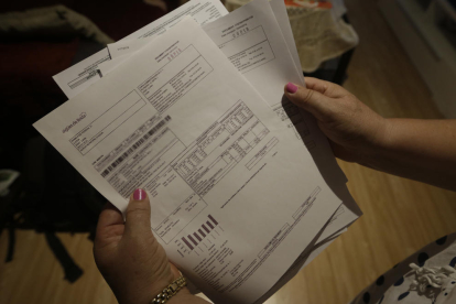 Una veïna mostra les factures d’aigua que sumen gairebé deu mil euros.