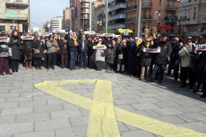 Los manifestantes han desplegado un gran lazo amarillo delante de la sede de Òmnium
