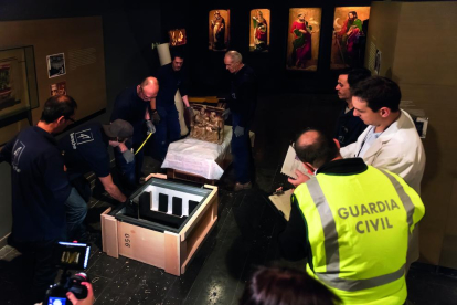 Una de las fotos del libro ‘Operació trasllat. Art de Sixena’, tomada en el interior del Museu durante la operación de traslado del arte, con los técnicos ‘rodeados’ de policía judicial y Guardia Civil.