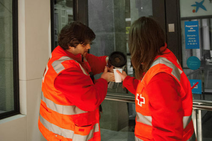 Dos voluntarios de Creu Roja Lleida sirven café.