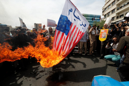 Iraníes queman banderas estadounidenses durante una manifestación contra la decisión de Trump.
