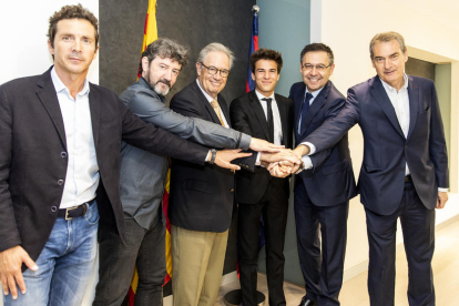 Riqui Puig, en el centro, con los representantes del Barça después de firmar su renovación.