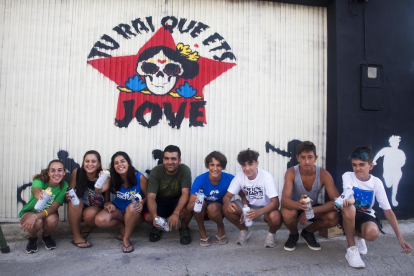 Algunos jóvenes con el artista Llukutter frente del mural. 