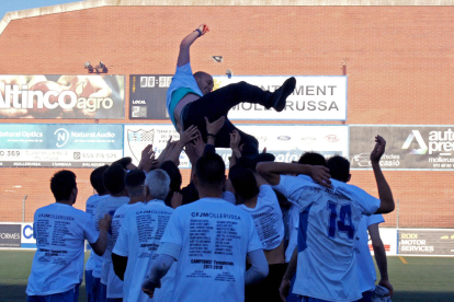 Los jugadores del Mollerussa y algunos aficionados celebran la victoria y el ascenso a Primera Catalana tras finalizar el partido contra el Solsona.
