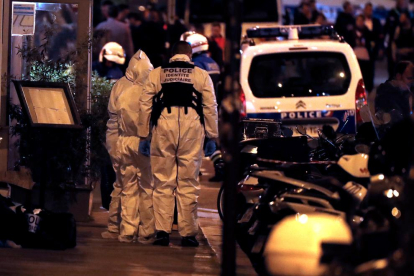Policías galos investigan el lugar del ataque durante la madrugada del sábado al domingo en París.