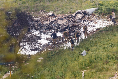 Soldats israelians inspeccionant les restes de l’F-16 abatut ahir per Bashar al-Assad.