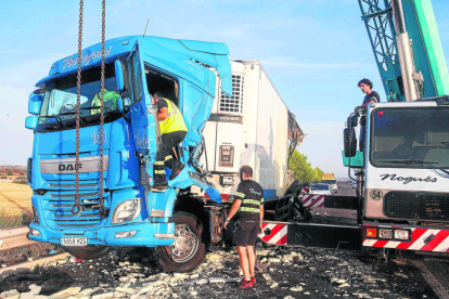 Operarios retiraron ayer con una grúa el camión arrollado por otro tráiler y en el que murió su conductor en la A-2 en Ribera d'Ondara.