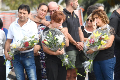 Familiars de les víctimes porten flors durant l’homenatge a Gènova.