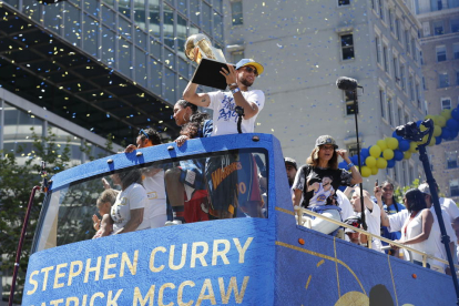 Stephen Curry levanta la copa durante la rúa por la ciudad.