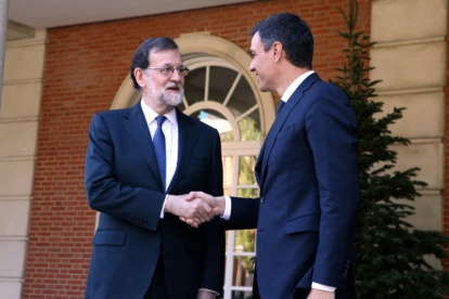 Mariano Rajoy i Pedro Sánchez se saluden a les portes de Moncloa abans de la reunió.