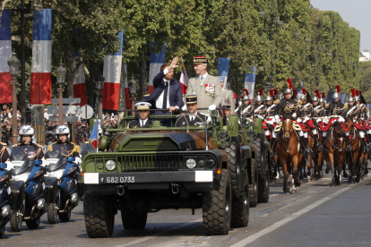 Macron saluda al público congregado a su llegada a los Campos Elíseos de París.