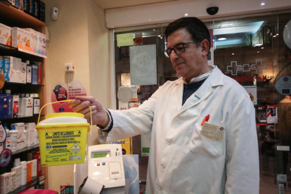 Contenidor de residus per dipositar les xeringues usades a la farmàcia Aragonès de Lleida.