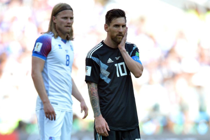 Messi se toca la cara mientras espera que le llegue el balón ante la vigilancia de Bjarnason.