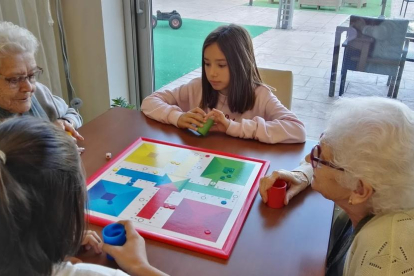 Niños de la escuela Doctor Serés de Alpicat se reúnen con los usuarios de la Residencia Sant Josep para jugar juntos a juegos de mesa. 